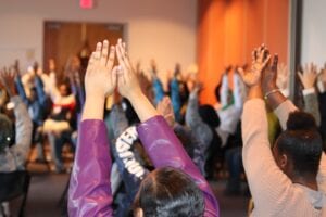 Image Initiative group holds their hands in the air.