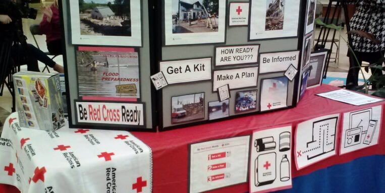 The American Red Cross promotional table displaying its efforts and initiatives.