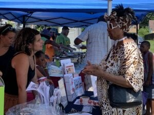 Two women speaking over an information booth