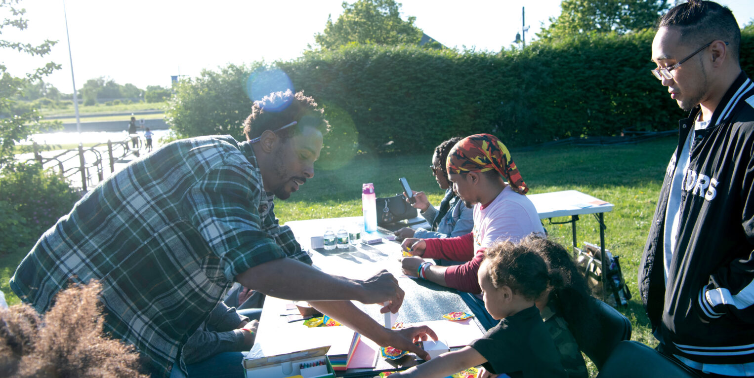 Man helping children with arts and crafts outside