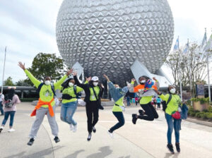 Group of teens jumping in front of sculpture